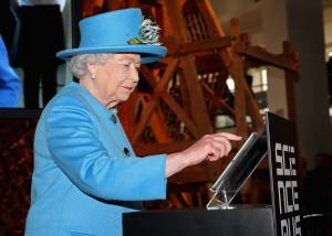 Britain's Queen Elizabeth presses a button to send her first Tweet during a visit to the 'Information Age' Exhibition at the Science Museum, in London