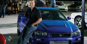 PAUL WALKER as agent Brian O'Conner leans against his 1998 Nissan Skyline GTR in the ultimate chapter of the franchise built on speed--